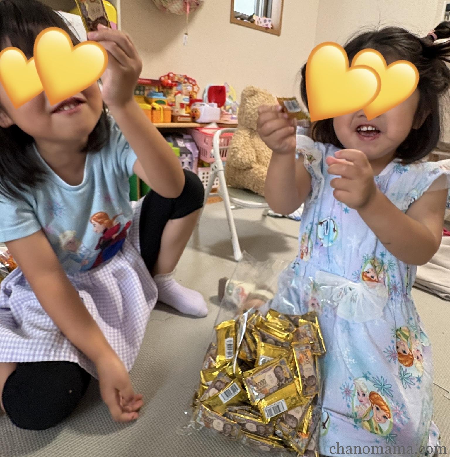 娘たちがお金型チョコレートの袋を持って嬉しそうにしている様子