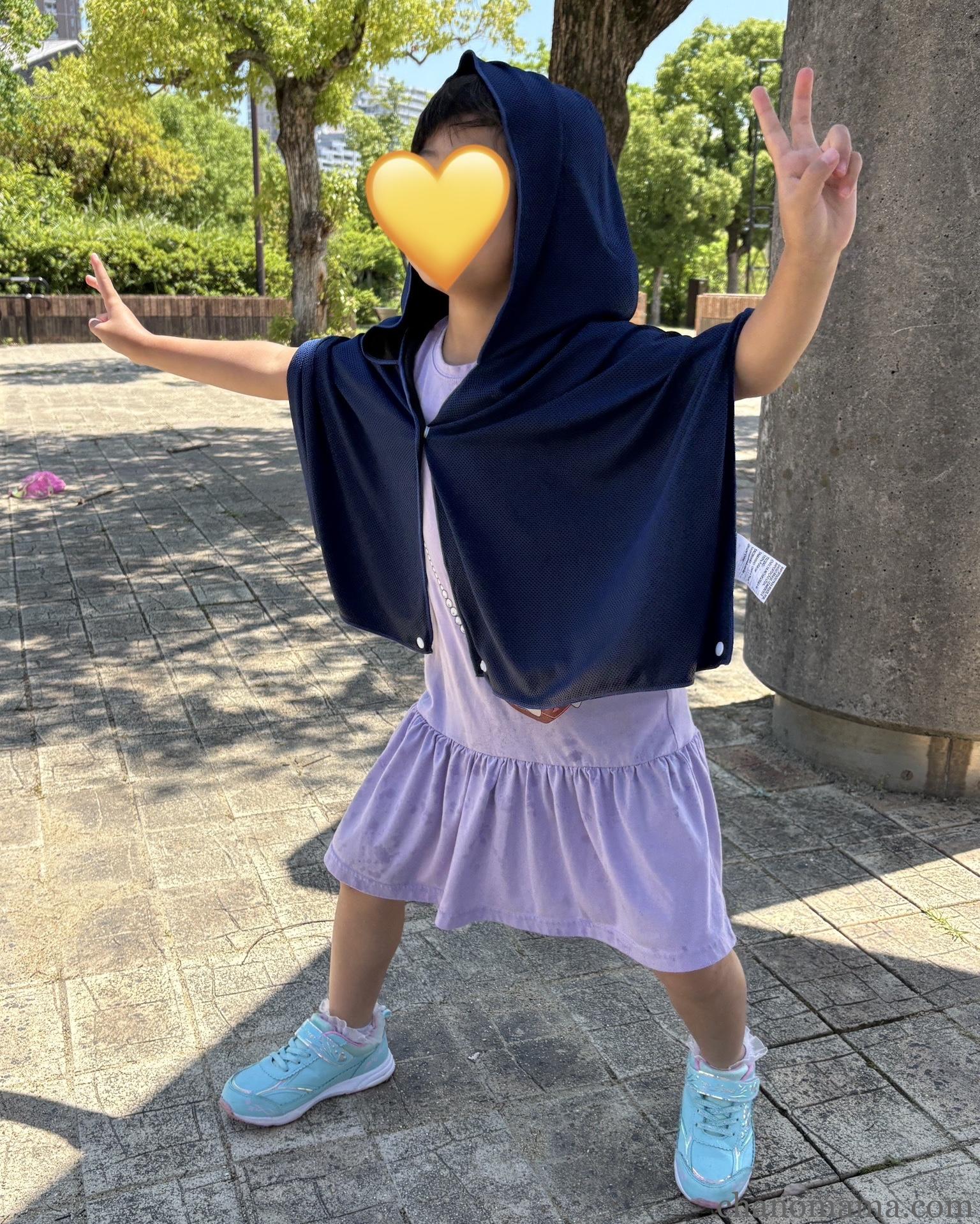 ダイソークールタオルポンチョを着た5歳の女の子・公園でフードをかぶっている後ろ姿